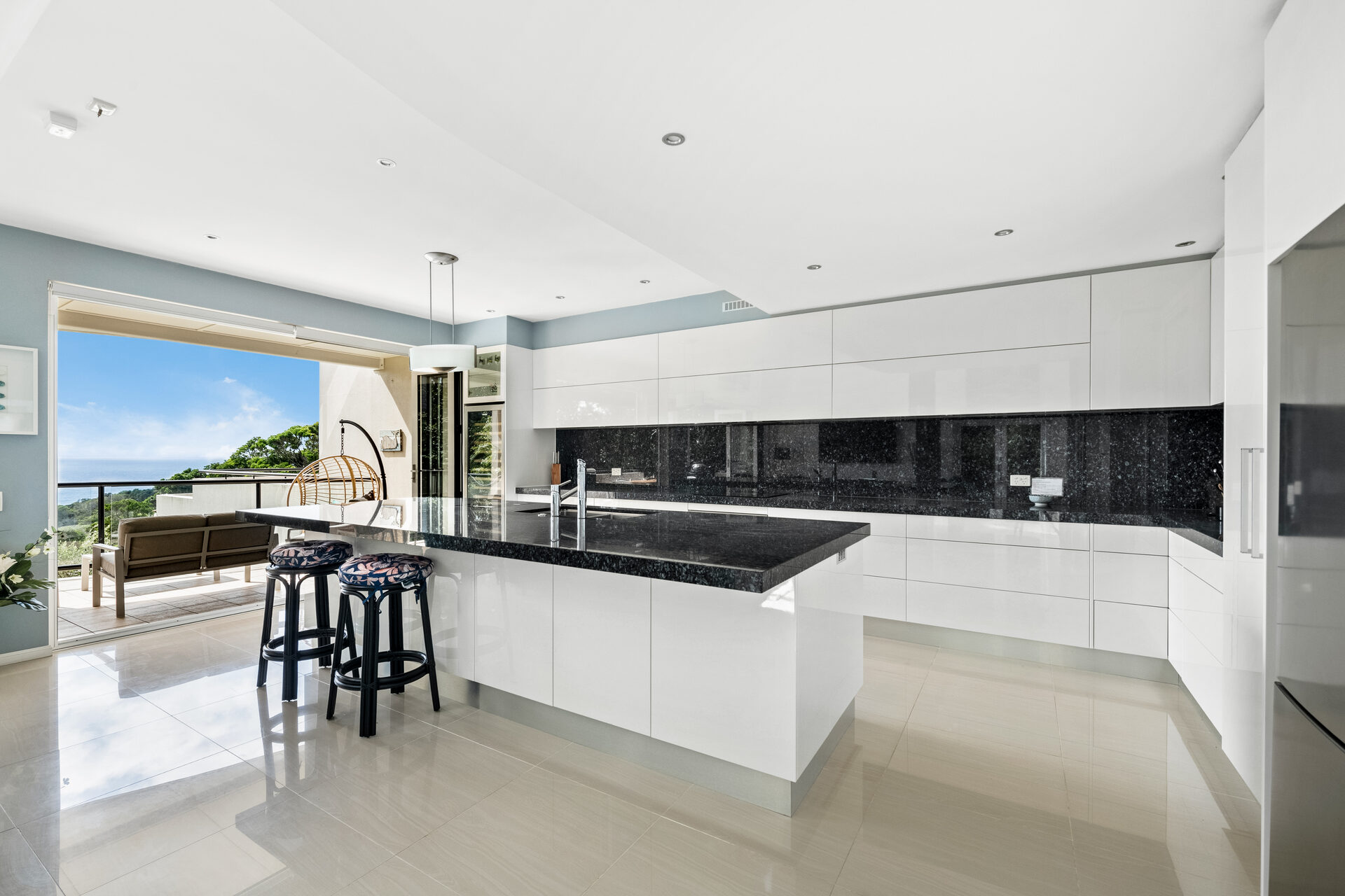 Modern kitchen with island, bar stools and ocean views