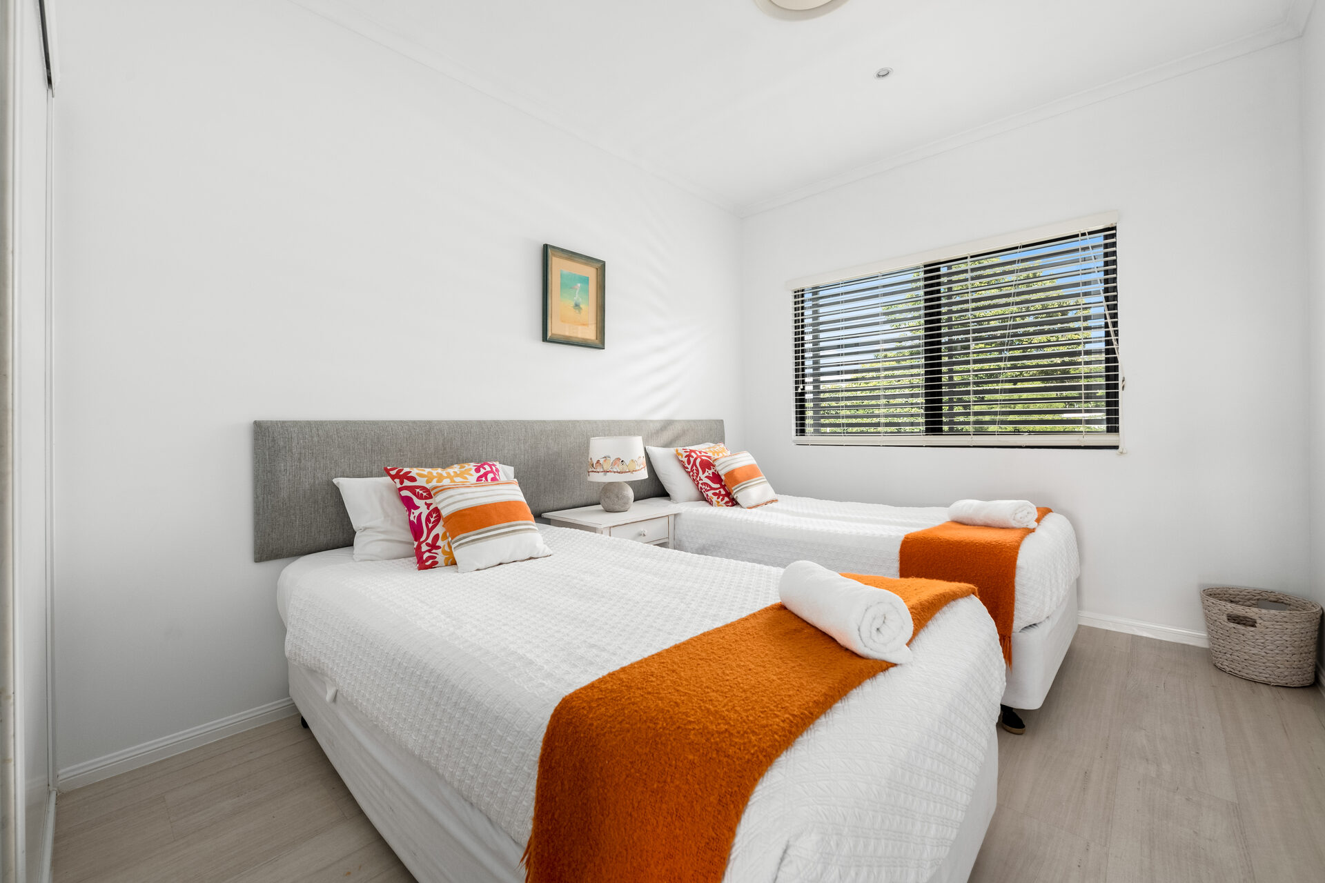 Twin single beds with orange throws